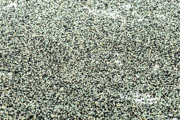 Background made from a macro photo of the inside of the filter with active carbon and water filtration pearls, selective focus in the center.