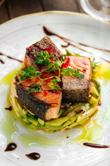 Gourmet cooked salmon fillet on cucumbers and apple