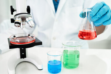 Asian scientist biochemist or microbiologist working research with a microscope in laboratory. For protect outbreak Coronavirus Covid19, bacteria and germs.