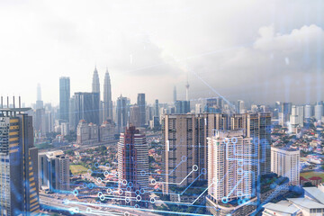 Technology hologram over panorama city view of Kuala Lumpur. KL is the largest tech hub in Malaysia, Asia. The concept of developing coding and high-tech science. Double exposure.