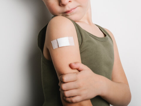 Anonymous schoolboy after vaccination with band aid on arm