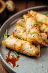 Turkish cigar shaped rolls boreks with sauce on wooden background