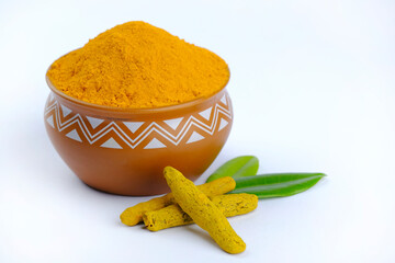 Turmeric Powder, Tumeric rhizome and turmeric powder in bowl isolated on white background, indian spice, healthy seasoning ingredient for vegan cuisine.