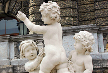 Vienna. Austria. 29 February 2020. Neue Burg Art Historical Museum steps decorated by Kids sculptures in Vienna at coudy summer day. Stone figures of three young children playing.