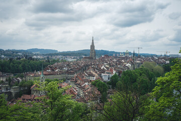 Fototapeta na wymiar A view of Bern, Switzerland from the hill of Rosengarten (Rose Garden), with the red roofs of the city below - Aargauerstalden Viewpoint