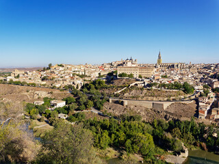 Fototapeta na wymiar The scenery of Toledo city in Spain with the old and historic buildings which is the UNESCO World Heritage Site with the trees and the Tagus river are in the foreground.
