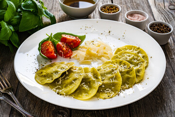 Medaglioni with cheese, basil and pine nuts on wooden table
