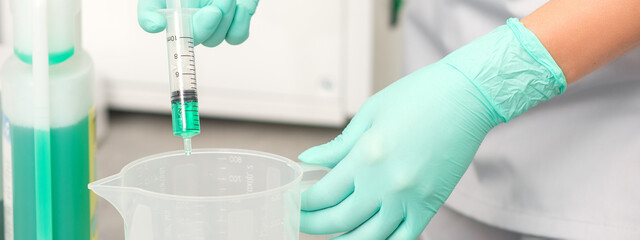 The beautician uses a syringe to add disinfectant to the water. Sterilization of tools