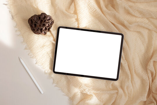 Tablet with pen on  beige background