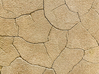 Bright beige concrete background with large cracks