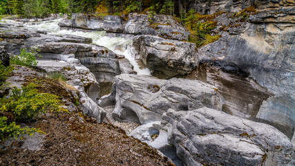 Obraz premium Turbulent water eroding the rocks of the Maligne Canyon in Jasper National Park, Alberta, Canada