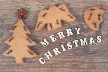 Inscription Merry Christmas with homemade gingerbreads and cookies for festive time