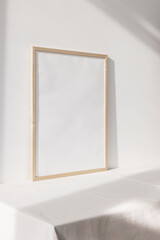 Wooden photo frame mockup on white wall 