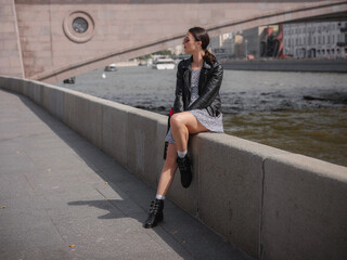 Beautiful woman walks on street at Moscow City sunny summer day.