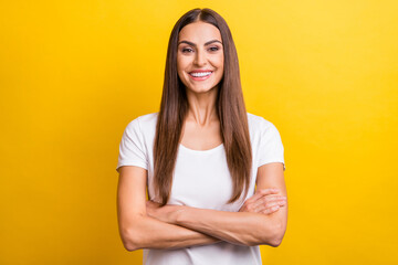 Obraz premium Photo portrait girl brown hair smiling crossed hands isolated vivid yellow color background