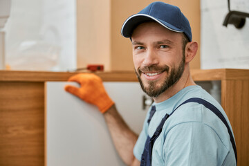 Joyful male worker looking at camera and smiling