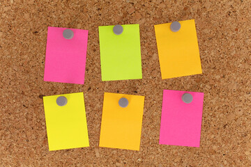 Blank colorful paper notepad reminder sticky notes on cork bulletin board. Empty space for text....
