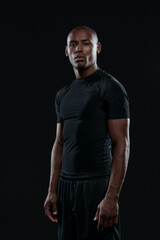 Young serious athletic black man looking at camera