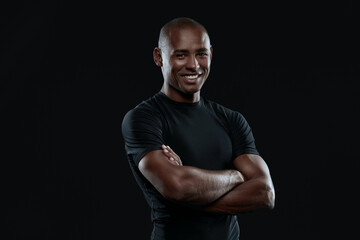 Young smiling athletic black man with crossed arms