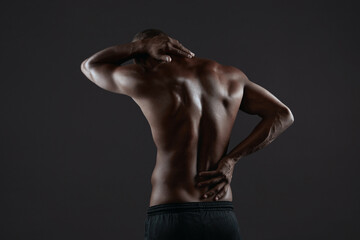 Fototapeta na wymiar Athletic black man touching his back with backache