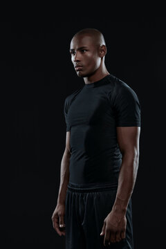 Young serious athletic black man looking away