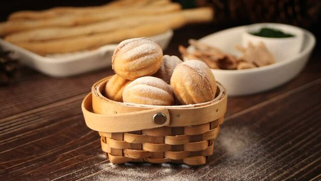 Woman hand take homemade fresh cookies in a shape of nuts with condensed milk