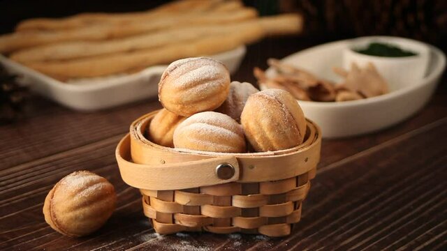 Powdered sugar is poured on Homemade fresh cookies in a shape of nuts with condensed milk
