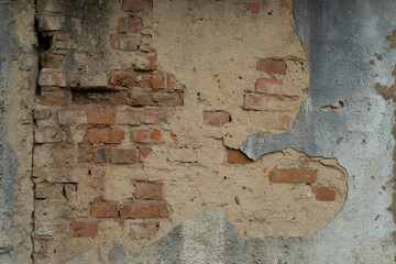 Texture of an old brick wall. Brick wall background with peeling plaster. Brick wall with fallen plaster.