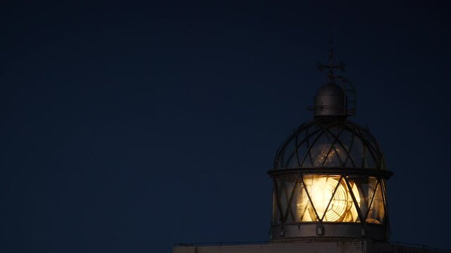Detail view. Lighthouse with beacon light in the night. Faro Cabo Busto on Asturias coast in Spain. Tourist attraction, place to visit.