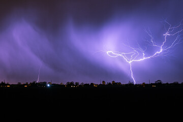 Bright branched bolt of lightning during an autumn thunderstorm