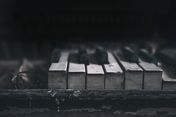 Black and white dirty keys of an abandoned piano. An old musical instrument. Play of light and...