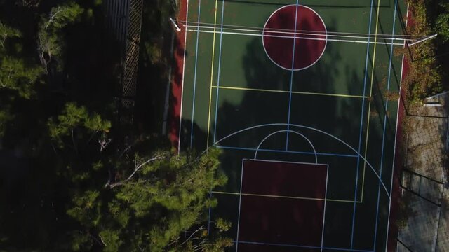 A common sports ground in a residential complex. Active recreation. Basketball rings and markings. Modern urban space. Top view 4k drone video