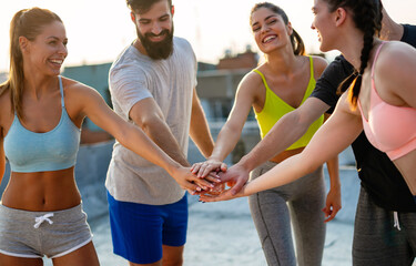 Group of happy fitness people training together outdoors, living active healthy lifestyle