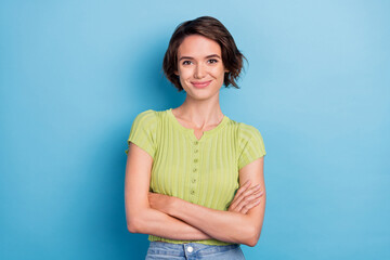 Photo of attractive confident young lady wear green t-shirt smiling arms crossed isolated blue color background - obrazy, fototapety, plakaty
