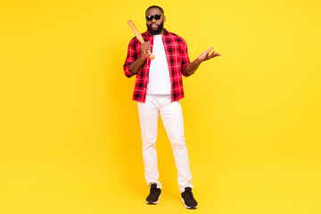 Full length photo of serious young man hands baseball bat isolated on yellow color background