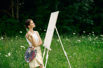 woman artist with palette of paints drawing easel nature hobby