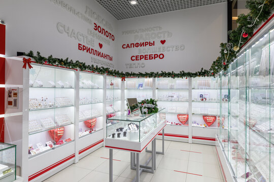 Minsk, Belarus - Nov 25, 2021: Photo of a jewelry store with bijous (earrings, rings, pendants) in a shopping center in New Year's red and white decorations. Christmas interior concept