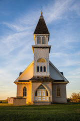An old country church in the Great Plains during sunset with fall colors in North Dakota.