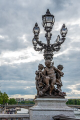 Fototapeta na wymiar Ornate classicist Street Light with three Cherub on bridge Alexandre III, Paris