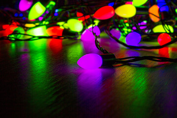 Purple Christmas light on the table. Christmas garland in the dark. High quality photo.