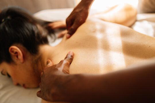 Hands of african american professional therapist giving back massage