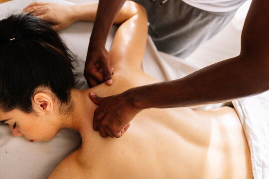 Hands of african american professional therapist giving back massage