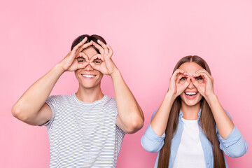 Photo of childish funny young couple wear casual clothes smiling showing hands arms glasses isolated pink color background