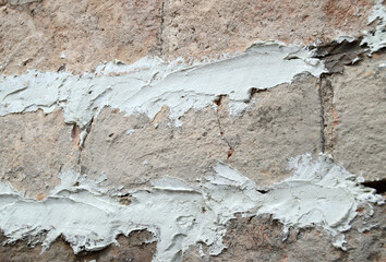 Patching an old dowel brick wall with lime mortar. Masonry work on a solid rustic brick wall