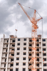 Fototapeta premium Powerful crane and construction of new apartments