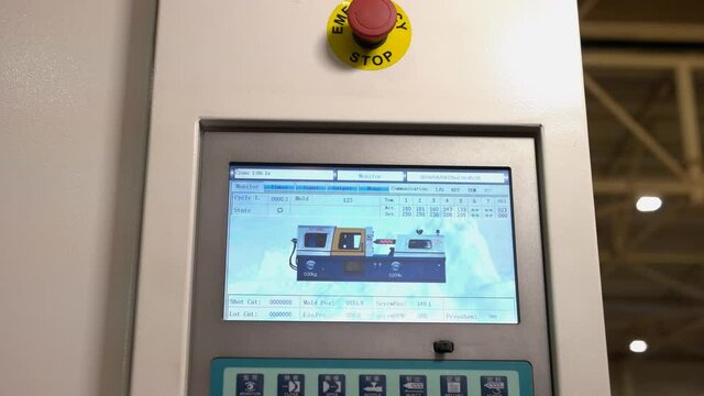 Control panel of molding machine and red emergency button.