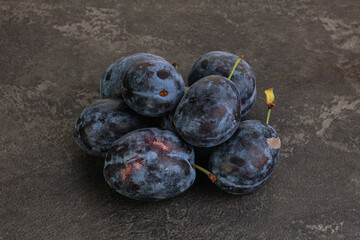 Ripe plum heap over background