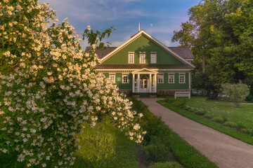 Traditional Russian manor of the late 18th century. 
 Lush blooming of snow-white jasmine in the foreground. Russia. Pskov. Pushkin mountains.