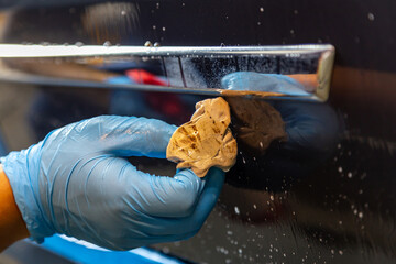 Clay bar used for cleaning cars in auto detailig , full of debris and dust after car cleaning close...
