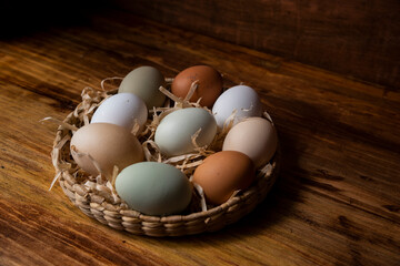 Canasta de huevos frescos de granja orgánicos libre pastoreo varios colores ordenados vistos desde arriba inclusión razas